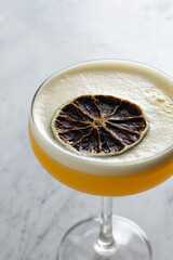 A view of a whiskey cocktail in a coupe glass.