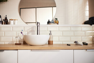 Modern bathroom countertop featuring skincare products, electric razor, toothbrush, soap dispenser and glass, reflecting daily beauty and skincare routine essentials for personal care