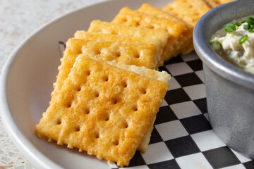 A closeup view of a pile of saltine crackers.