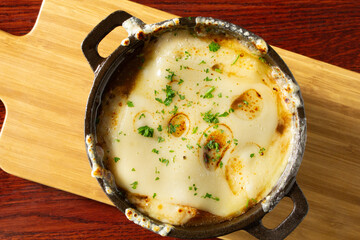 A top down view of a bowl of French onion soup.