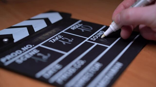 Movie clapperboard footage. Man hand holding film slate and clapping it in studio before shooting or recording. Movie clapper board or film slate for video recording. film production. film industry.