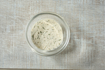 A top down view of a condiment cup of ranch dressing powder.