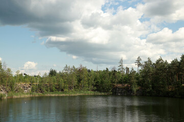 Beautiful quarry lake among forest and rocks