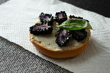 A view of a gluten-free bagel with diary-free cheese spread and blackberries.
