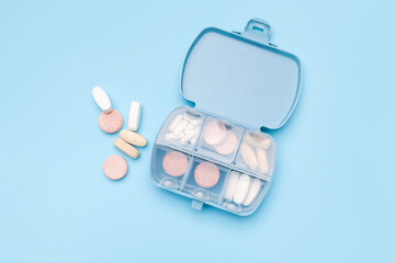Blue pill organizer, pillbox with different vitamins, capsules, tablets, pills, dietary supplements...