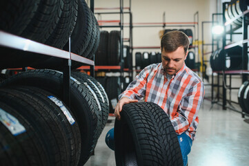 Man chooses winter car tires in the auto shop © Serhii