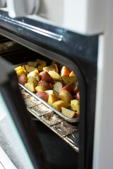A view of a baking tray of roasted potatoes inside the oven.