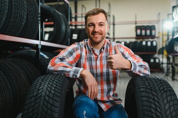 Man chooses winter car tires in the auto shop
