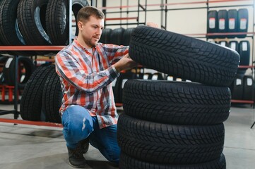 Man chooses winter car tires in the auto shop