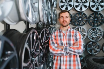 Car mechanic holding car rims ready to mount the wheels in workshop