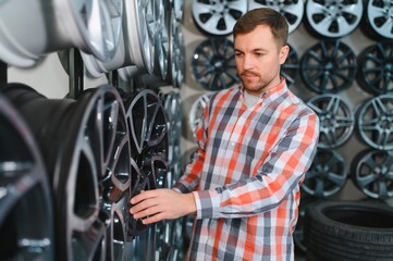 Car mechanic holding car rims ready to mount the wheels in workshop