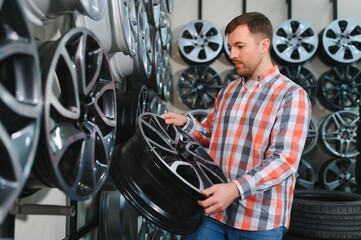 The buyer chooses new alloy wheels for his car