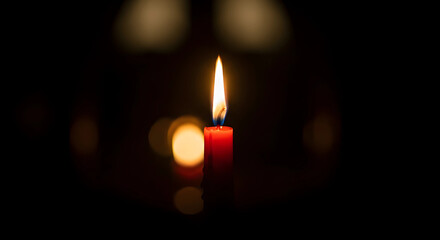 Burning candle in the dark background
