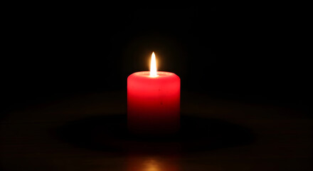 Red burning candle in the dark
