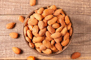 Raw peeled almonds in brown wooden bowl. Organic food concept. 