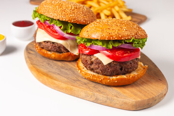 Hamburger made of beef, onion, tomato, lettuce, cheese and spices. Fresh burger closeup. Cheeseburger.