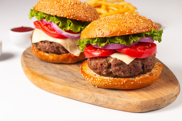 Hamburger made of beef, onion, tomato, lettuce, cheese and spices. Fresh burger closeup. Cheeseburger.