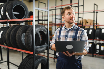 Portrait of a worker in a new car tire shop. Concept of changing tires