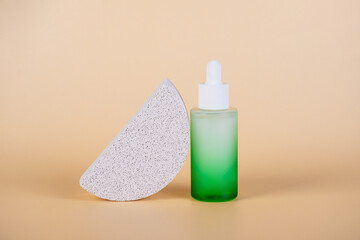 Green glass cosmetic bottle, Skin care or sunscreen cosmetic with stylish props on cream background.