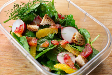 A view of a plastic container of citrus and fennel salad.