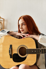 Young beautiful woman enjoying her spare time with a guitar in a cozy living space
