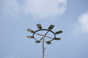 A modern high mast street light with multiple LED lamps in a circular frame. Low angle view against...