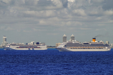 Modern cruiseships cruise ship liners Magica, Seaside, Armonia and Fortuna anchored offshore of South Miami Beach on sunny day with blue sky and sea