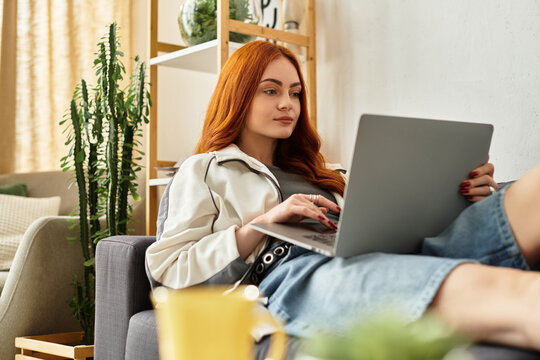 Young woman enjoying leisure time while using laptop in cozy living room setting