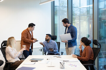 A diverse team engages in a collaborative meeting at a modern office, discussing ideas and...