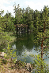 Beautiful quarry lake among forest and rocks