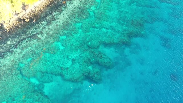 Cliffs and rocks of Tokoriki tropical island in Fiji surrounded by coral reefs and beaches.
