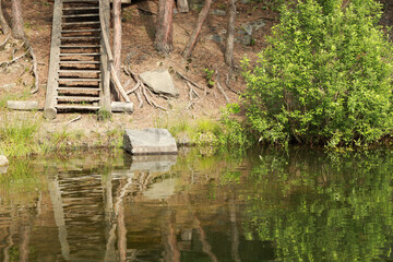 Wooden stairs on a hill at lake in the forest