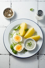 Hard boiled eggs with potato and green sauce
