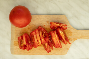 sliced tomato on cutting board for Hungarian lecsó