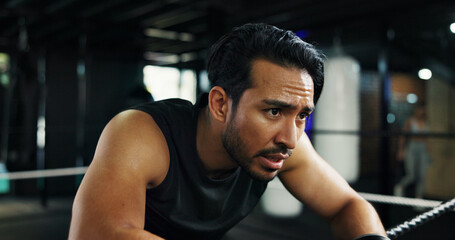 Breathing, sweating and tired with man in boxing gym for break, recovery or rest from training....