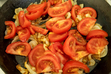 sliced peppers, onions, and tomatoes cooking in frying pan for Hungarian lecsó