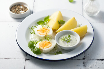 Hard boiled eggs with potato and green sauce