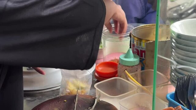 Packing Indonesian soto &mdash; hot, savory soup carefully wrapped for takeaway, capturing the flavors of street food culture and local comfort meals. June 2, 2025 - Karet, Indonesia