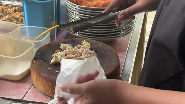 Packing Indonesian soto &mdash; hot, savory soup carefully wrapped for takeaway, capturing the flavors of street food culture and local comfort meals. June 2, 2025 - Karet, Indonesia