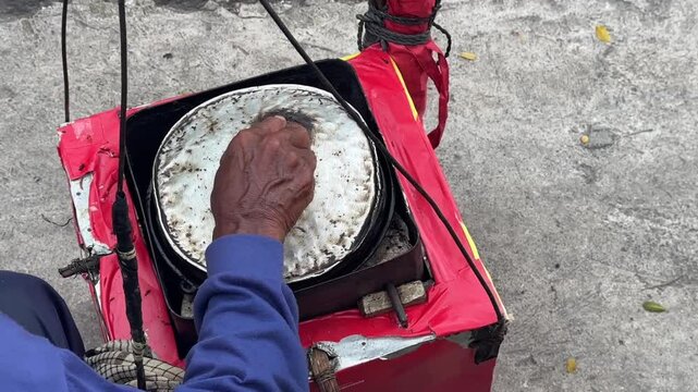 Street vendor preparing kue cubit &mdash; a popular Indonesian mini pancake snack cooked fresh on the roadside, loved for its soft texture and nostalgic flavor. Karet, Indonesia - June 25, 2025
