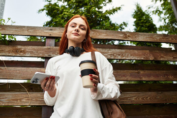 Young woman enjoys a coffee while relaxing outdoors during her spare time