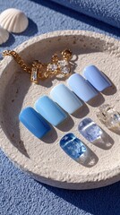Stylish blue manicure samples display with trendy jewelry accents on a textured surface.