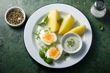 Hard boiled eggs with potato and green sauce