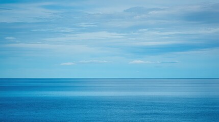 Peaceful ocean view with blue sky and soft clouds meets the tranquil water