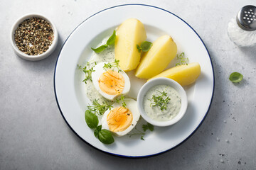 Hard boiled eggs with potato and green sauce