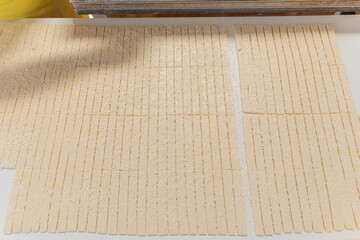 Thinly rolled and cut into strips of dough for crackers.