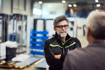 Senior Professional Discussing Strategies in a Modern Industrial Facility