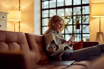 Woman Relaxing on a Sofa and Using Phone in a Cozy Living Room
