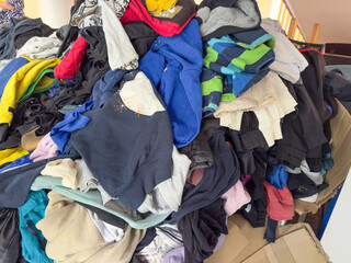 Large pile of mixed used clothing in various colors and styles. Concept of textile recycling, second-hand donation, or fashion waste. sustainability, reuse, Lost and Found, Laundry Chaos, Thrift Store