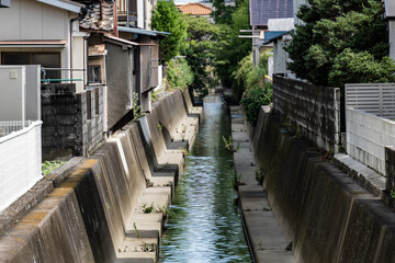 密集した住宅街の間を流れる水路,